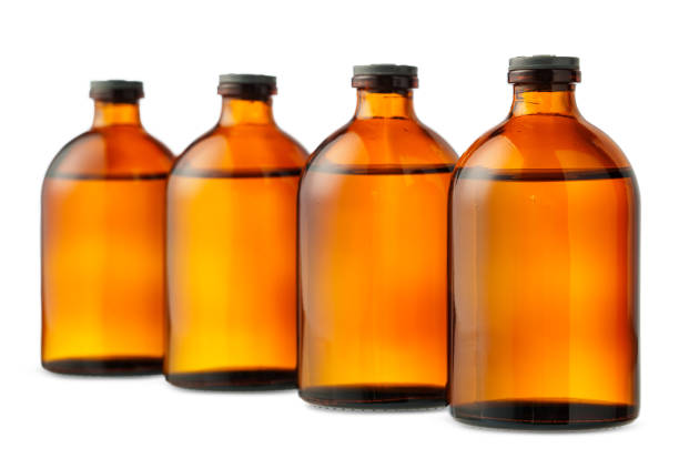 istock Four Amber Glass Bottles With Black Caps on a White Background 2160024979