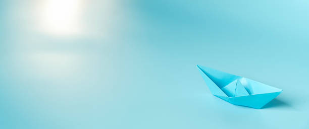 istock Handmade paper boats on light blue background.  Space for text. 2160025590