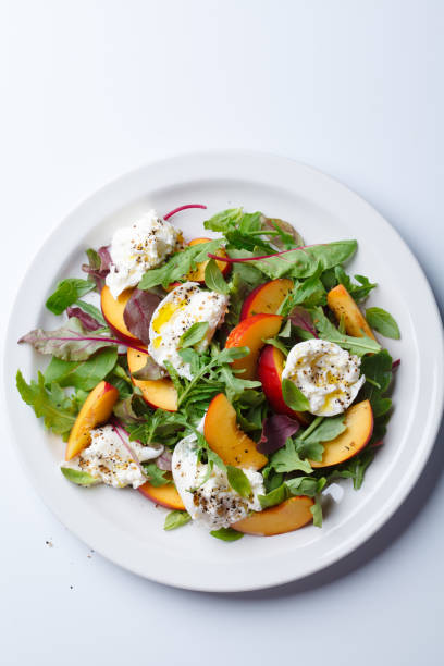istock Burrata and peaches summer salad, white background. 2160026781