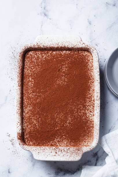 istock Homemade tiramisu in baking dish on white marble table. 2160027704