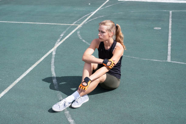 istock young female boxer training in the stadium, having rest sitting 2160038335