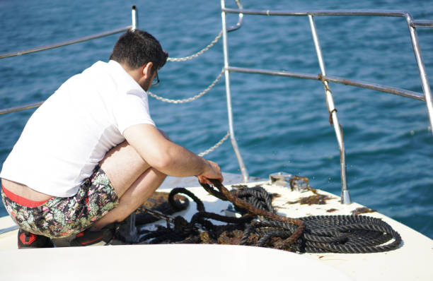 Small white motor boat with one adult man on board runs fast in the blue Mediterranean sea on a sunny summer day, back view. Gulf of La Spezia, Liguria, Italy, southern Europe.