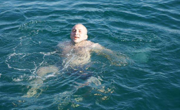 Man swims in the sea at dawn