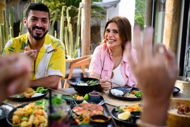 istock Laughing vacationers eating resort lunch 2160044113