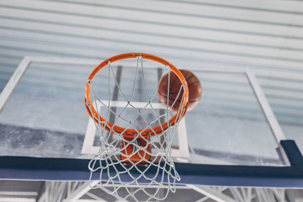 istock Basketball ready to enter the hoop seen from below 2160046384