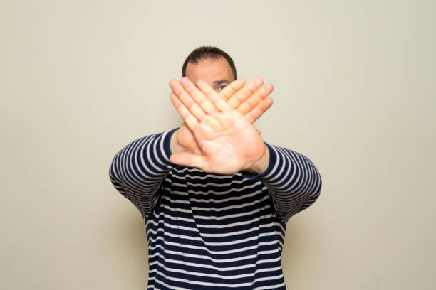 istock Hispanic man with beard standing over beige background rejection expression crossing arms and palms doing negative sign. 2160047452