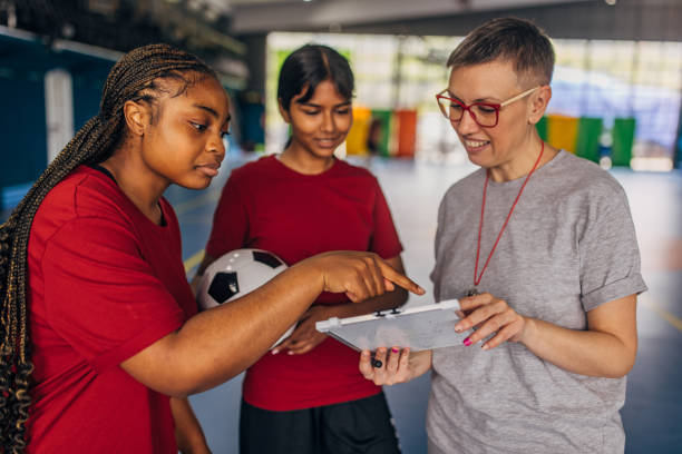 istock Coach and soccer players reviewing game plan indoors 2160048355