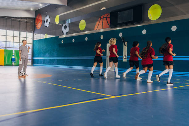 istock Coach supervising athletes during indoor training run 2160052093