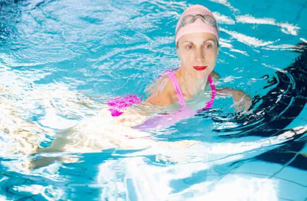 istock Relaxed swimmer in pink enjoying indoor pool, copy space. 2160052811