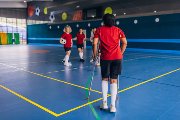 istock Crutches player approaches teammates indoors 2160052851