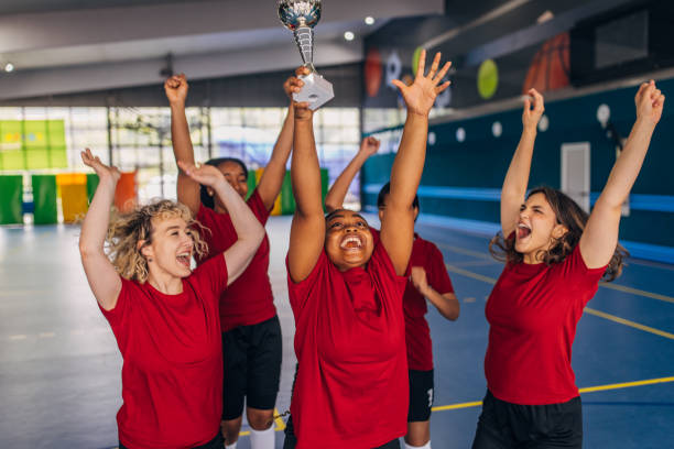 istock Elated teammates lifting a trophy in celebration 2160053415
