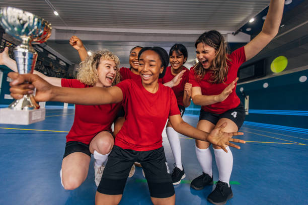 istock Female athletes celebrating win holding trophy together. 2160055193