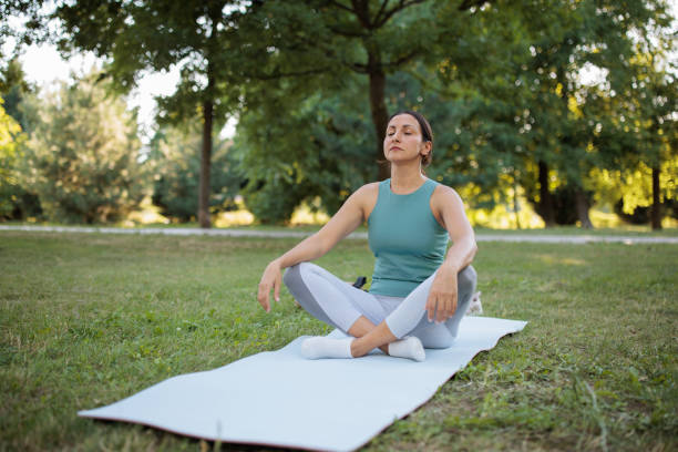 istock Woman doing yoga in a park 2160056689
