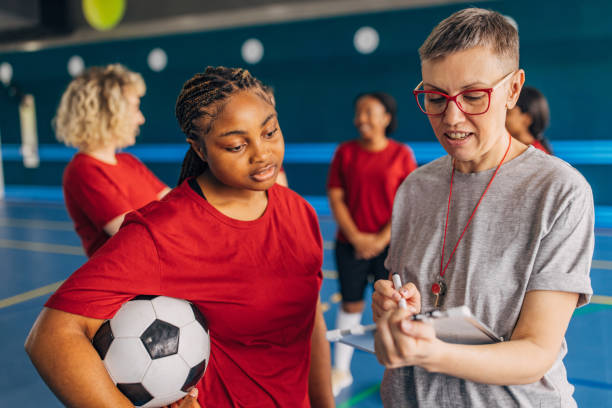 istock Focused coach instructs young female soccer team. 2160057265