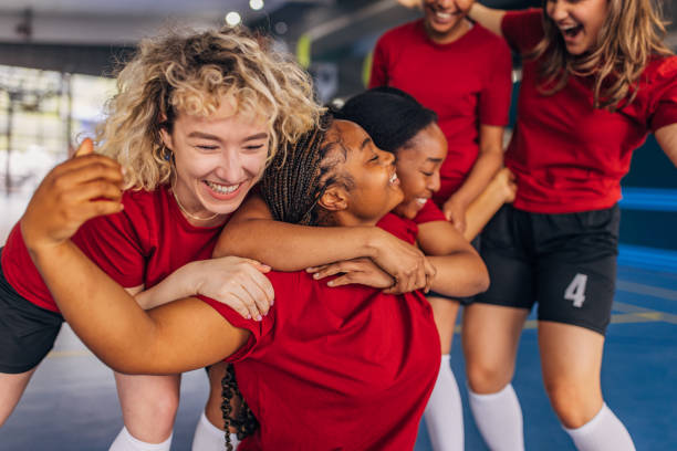 istock Group hug among cheerful teammates after a win 2160058622