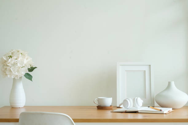 istock Empty picture frame, coffee cup, headphone and ceramic vase on wooden table. 2160059695
