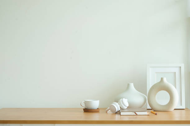 Empty picture frame on wooden  table with modern white ceramic vase.