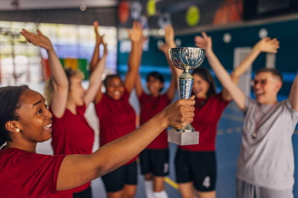 istock Jubilant team lifting trophy celebrating victory 2160062022