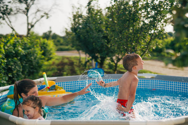 istock Woman with her children in  pool. 2160063020