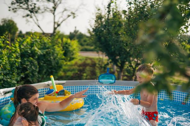 istock Woman with her children in  pool. 2160063118