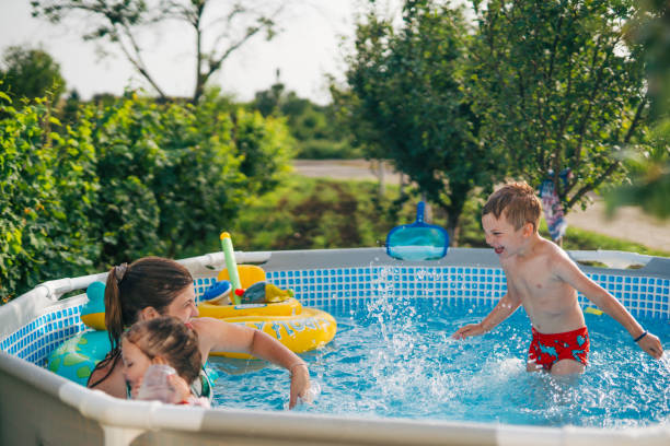 istock Woman with her children in  pool. 2160063300