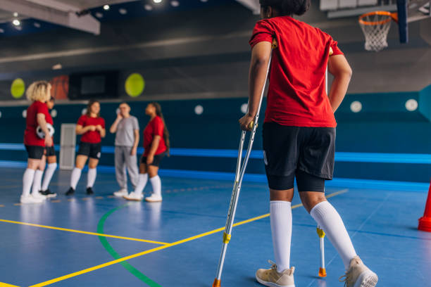 istock Soccer player with crutches moving towards teammates 2160064740