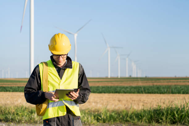istock Engineer with digital tablet works on a field of wind turbines 2160065238