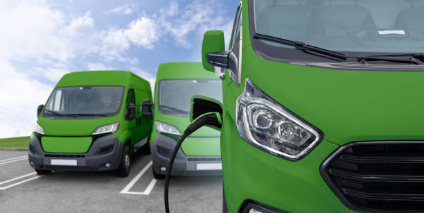 istock Green electric delivery van with connected charging cable 2160065412