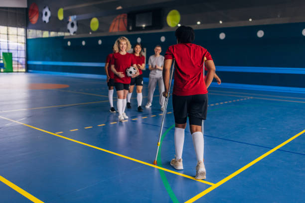 istock Team gathers around player with crutches indoors 2160066263