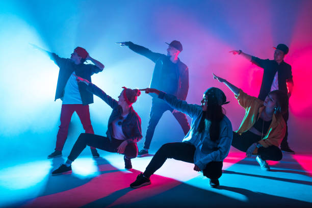 istock Group of diverse young hip-hop dancers in studio with special lighting effects 2160066435