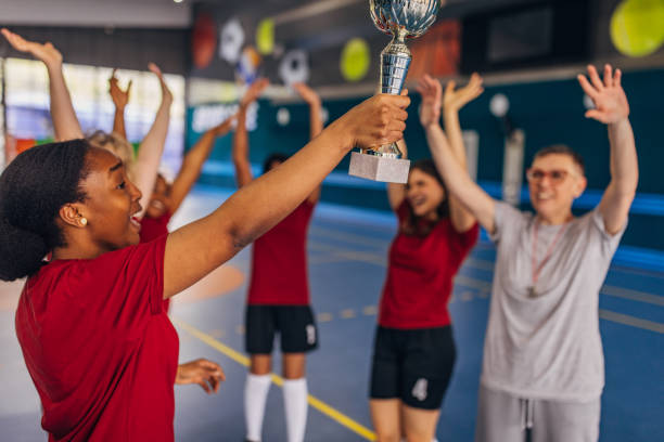 istock Team lifting trophy in cheerful celebration indoors 2160066723