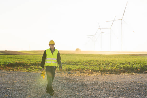 istock Engineer with digital tablet works on a field of wind turbines 2160067171