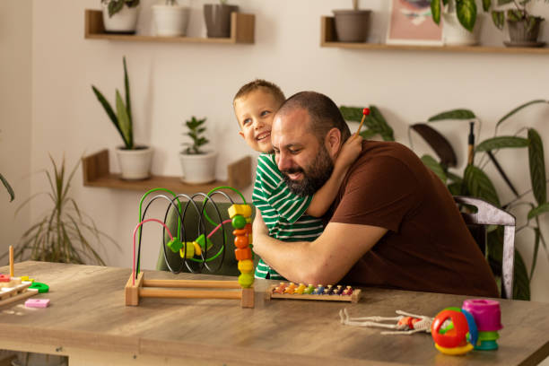 Father and son explore new toys side by side and enjoy their time together. Father as an important figure in a child's life.