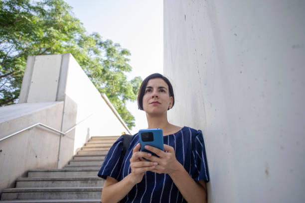 istock Woman using the mobile phone outdoors 2160073145
