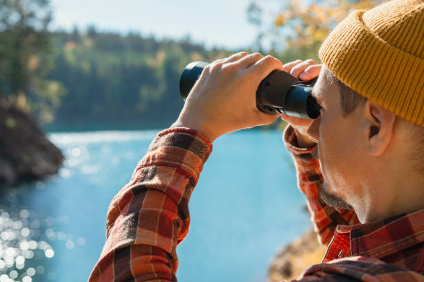 istock man with binoculars close-up looking at birds on a lake or river Birdwatching 2160073634