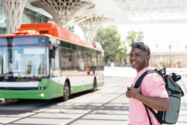 istock A man wearing a backpack stands in front of a green 2160077525