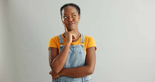 istock Black woman, studio and thinking of ideas for problem solving or planning, insight and brainstorming for decision. Girl, thoughtful and isolated on white background with mockup, pensive and choice. 2160078657