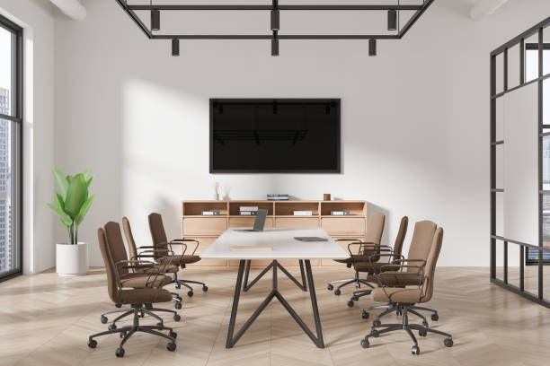 istock Stylish office interior with meeting table and chairs, tv screen and window 2160079344