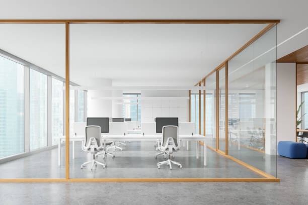 istock White office interior with pc computers and furniture, panoramic window 2160081877
