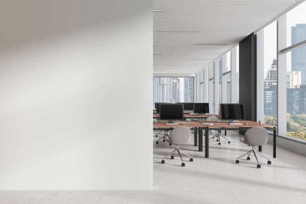istock White coworking interior with table and pc monitors, window. Mockup wall 2160082197