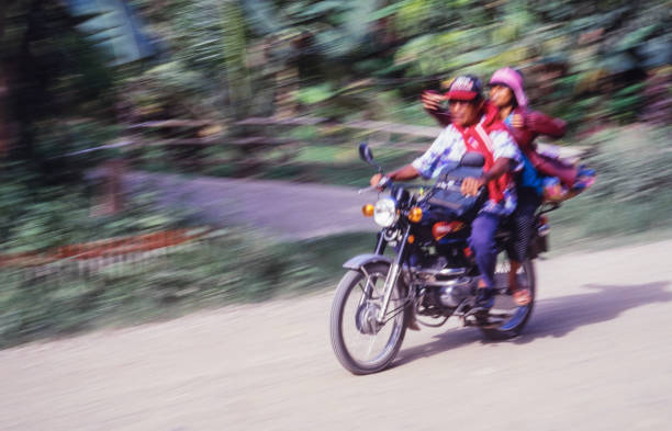 Tablas Island, Philippines - June 23, 2024: Motion blur image of a couple riding a motorcycle on a rural road on the island