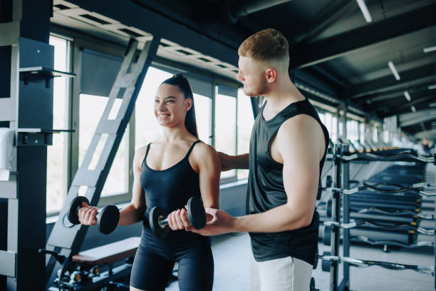 istock Dumbbell Routine Male Personal Trainer Supports Woman's Exercise 2160087878