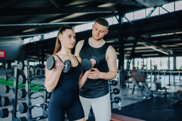 istock Dumbbell Training Male Personal Trainer Helps Woman with Workout 2160087899