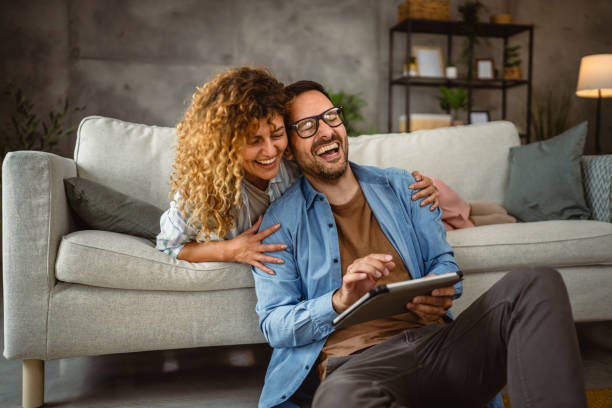 istock Boyfriend sit on the floor use tablet while girlfriend lie and hug him 2160089193