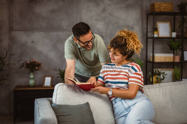 istock girlfriend sit on sofa read book and discuss whit her boyfriend 2160090237
