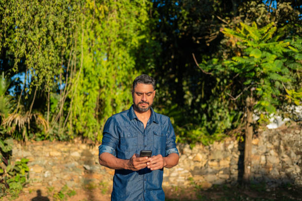 istock Portrait of a man using cell phone in a park 2160090753
