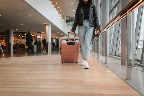 istock Young woman pulling her luggage at the airport 2160091103