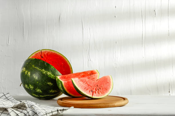 istock Fresh watermelon slices on white wooden board table top and white wall with sunlight background. 2160094930