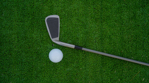 istock Golf ball and wooden driver on green grass background. 2160099594