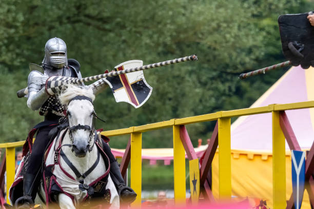 Linlithgow, Scotland - 30th Jun 2024: Man garbed as a medieval knight during a reenactment event at Linlithgow Palace, Scotland.  During the event, people dressed as knights and other medieval characters perform jousts on horseback and battle using replica weapons and armour, and demonstrate various skills and work based on medieval techniques.Such events are a popular attraction for both tourists and locals during the summer season.